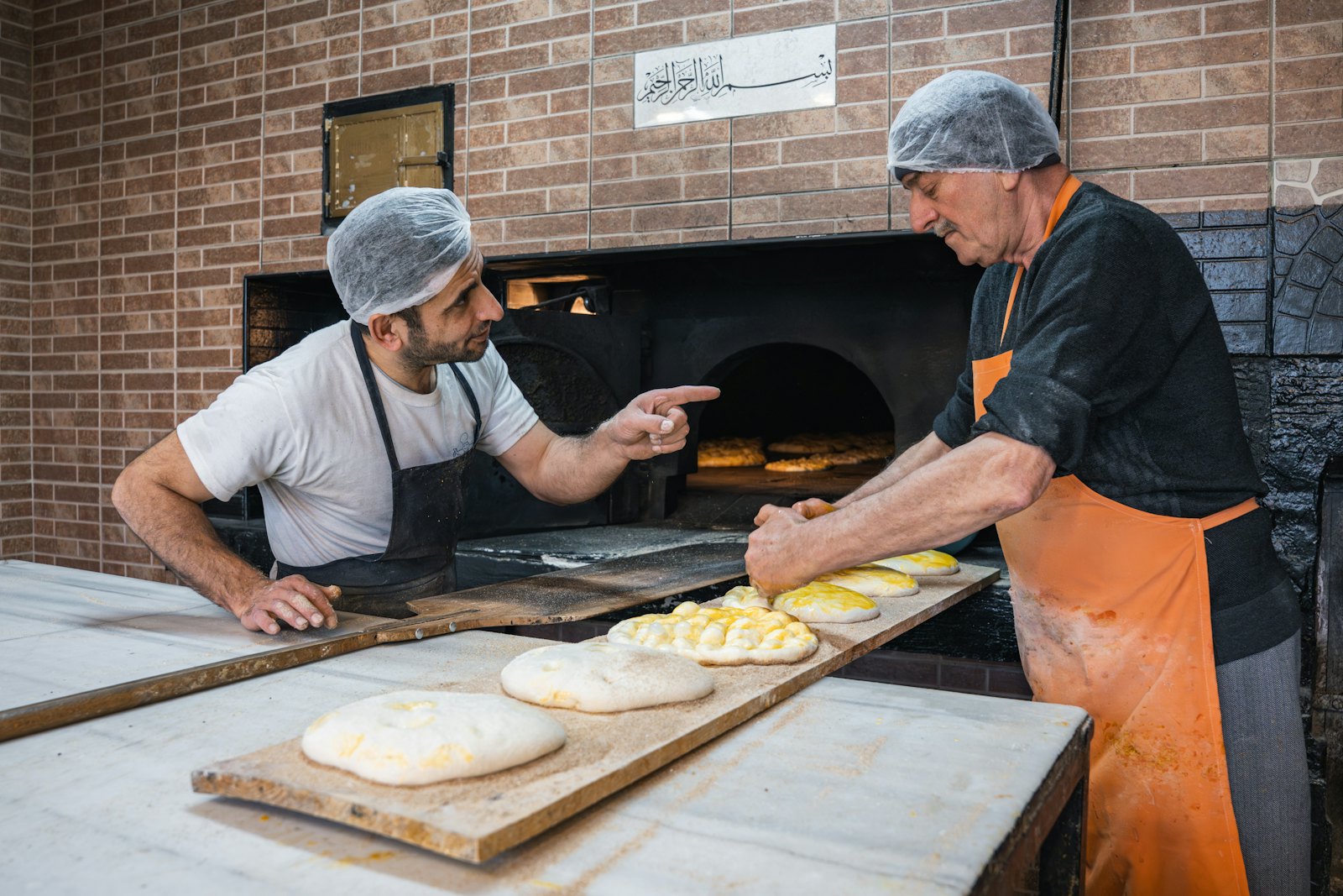Two bakers at the oven